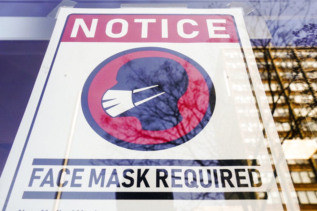 A sign requiring masks as a precaution against the spread of the coronavirus is posted on a store front in Philadelphia, on Feb. 16, 2022. The Biden administration will significantly loosen federal mask-wearing guidelines to protect against COVID-19 transmission on Friday, according to two people familiar with the matter. (AP Photo/Matt Rourke, File)