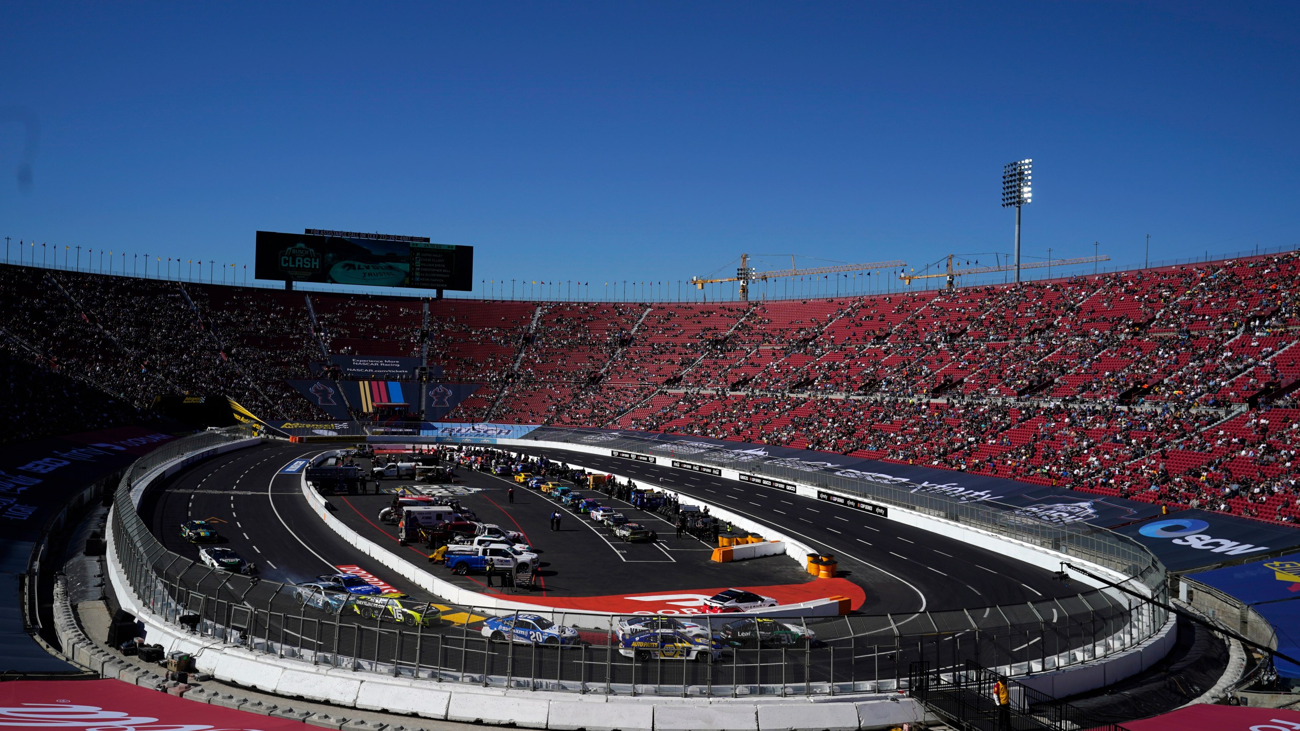 Competitors make a turn during a heat race ahead of a NASCAR exhibition auto race at Los Angeles Memorial Coliseum, Sunday, Feb. 6, 2022, in Los Angeles. (AP Photo/Marcio Jose Sanchez)