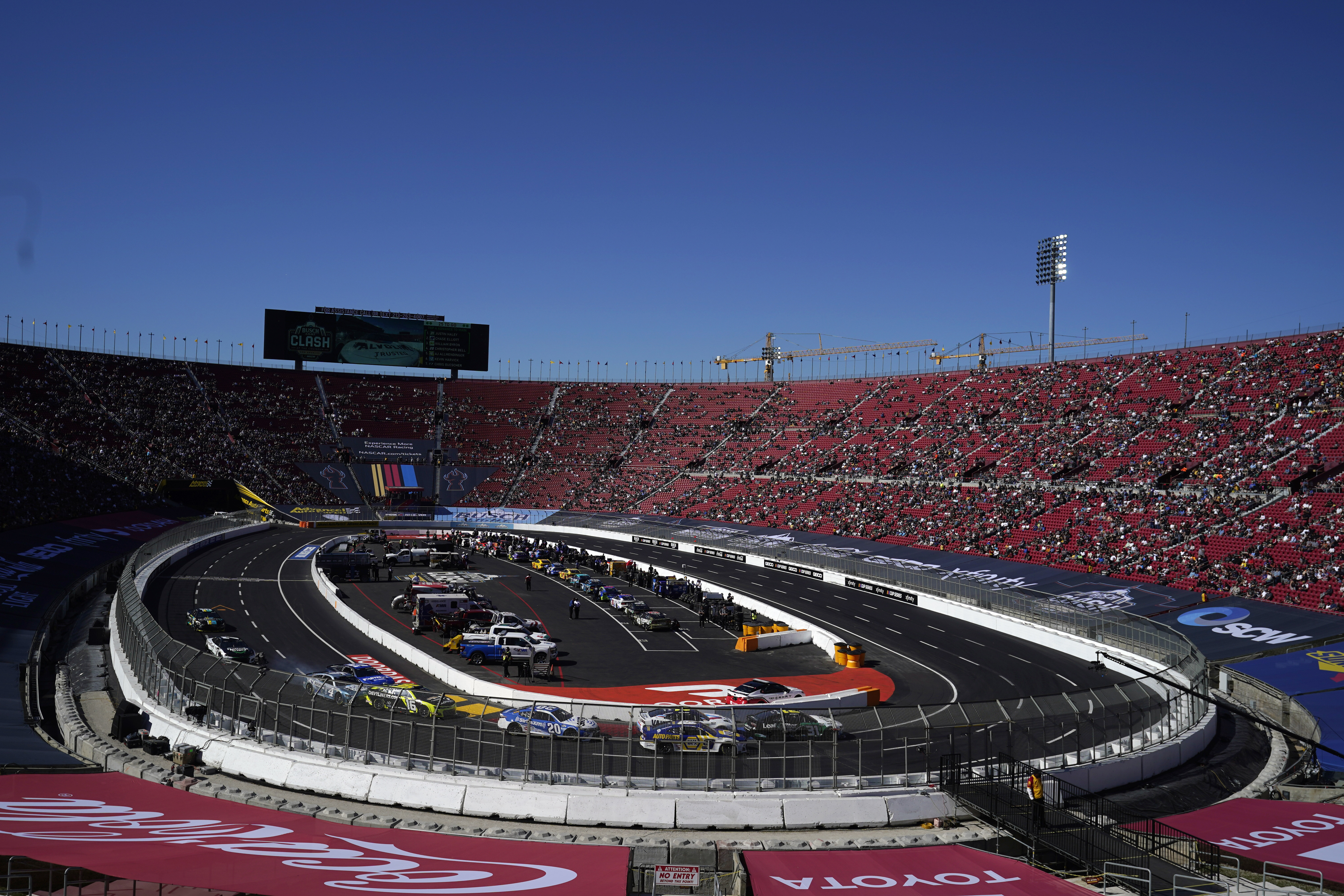 Competitors make a turn during a heat race ahead of a NASCAR exhibition auto race at Los Angeles Memorial Coliseum, Sunday, Feb. 6, 2022, in Los Angeles. (AP Photo/Marcio Jose Sanchez)