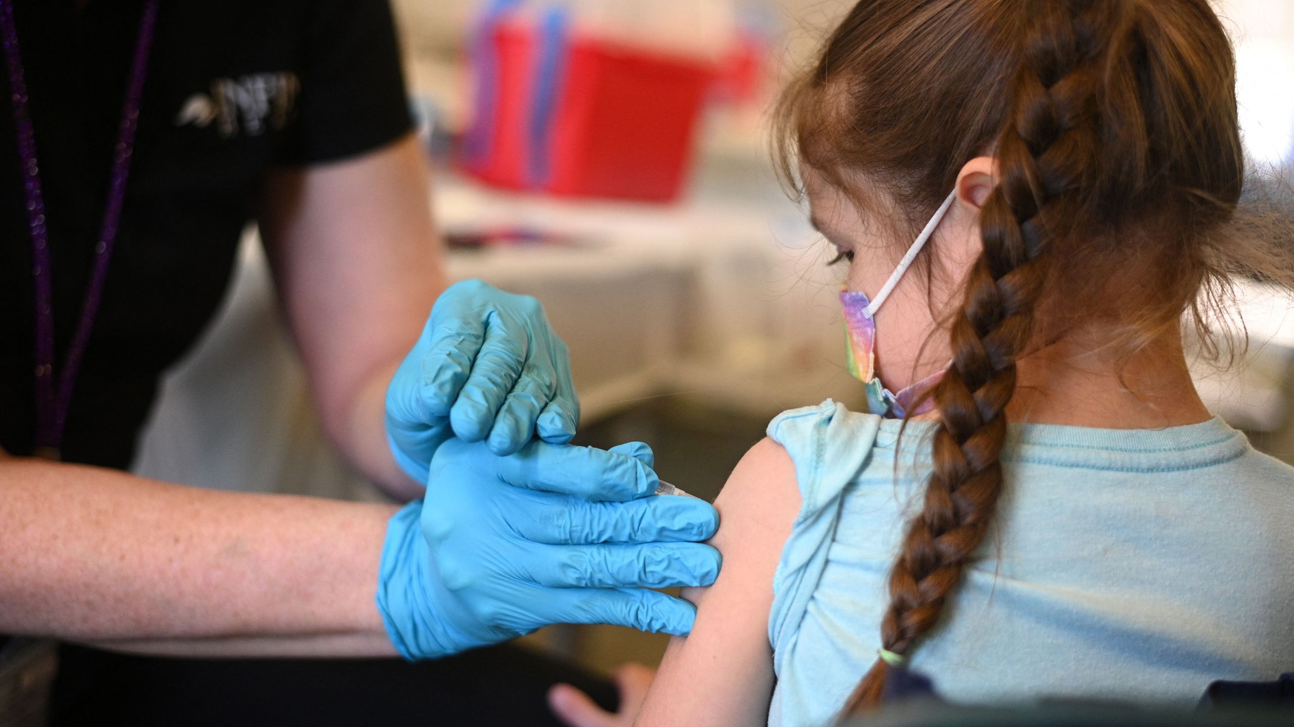 A nurse administers a pediatric dose of the COVID-19 vaccine to a girl at a L.A. Care Health Plan vaccination clinic at Los Angeles Mission College in the Sylmar neighborhood of Los Angeles, California on Jan. 19, 2022. (ROBYN BECK/AFP via Getty Images)