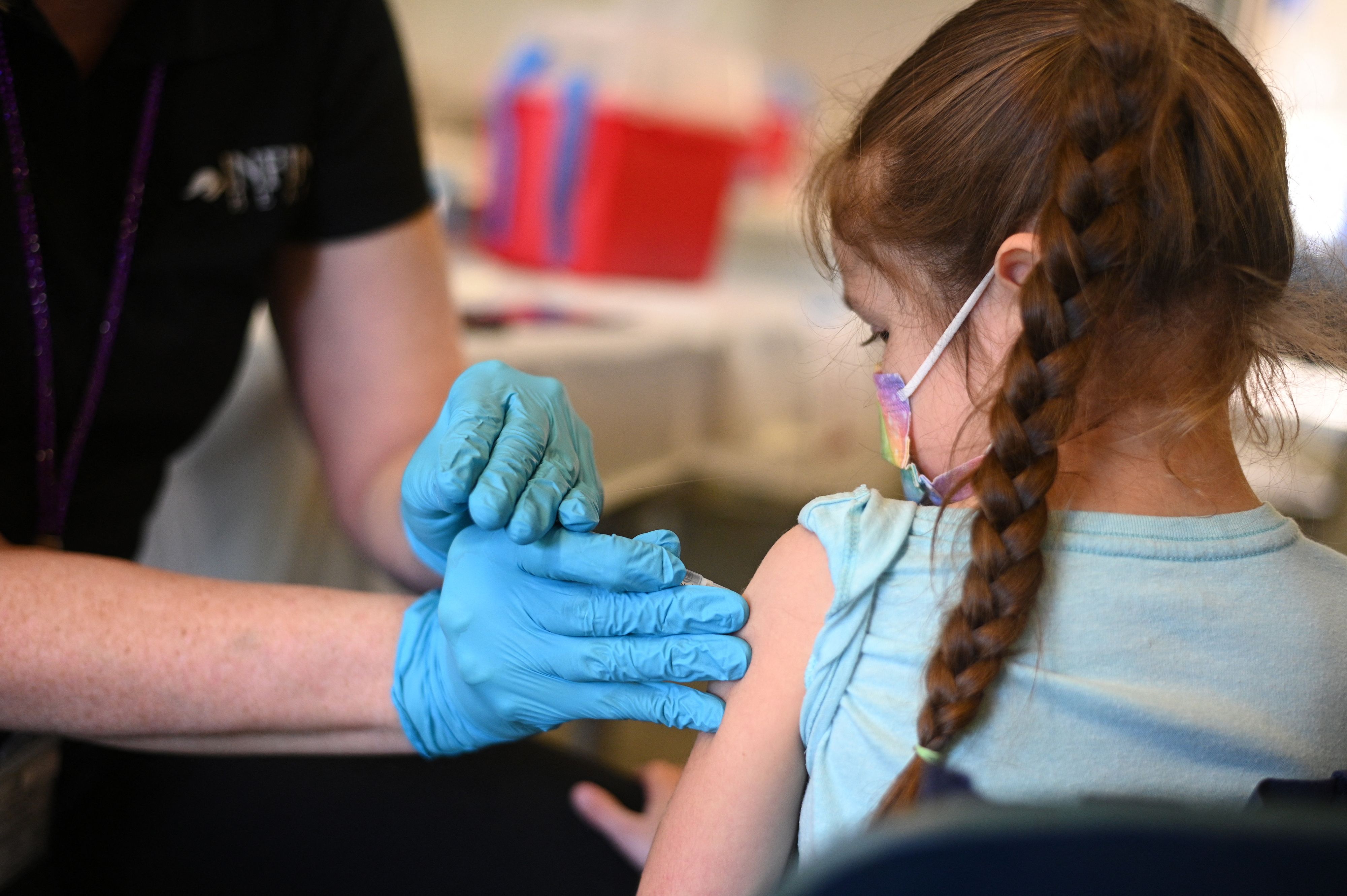 A nurse administers a pediatric dose of the COVID-19 vaccine to a girl at a L.A. Care Health Plan vaccination clinic at Los Angeles Mission College in the Sylmar neighborhood of Los Angeles, California on Jan. 19, 2022. (ROBYN BECK/AFP via Getty Images)