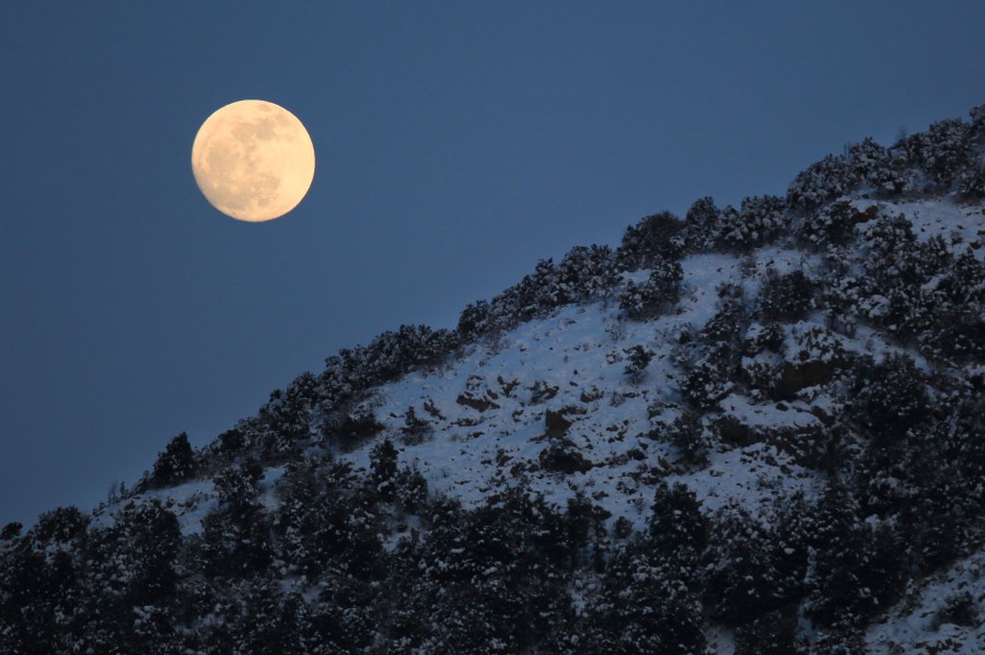 A picture taken on February 6, 2012 shows the moon behind snow covered landscape near the Corsican village of Bastelica. (PASCAL POCHARD-CASABIANCA/AFP via Getty Images)