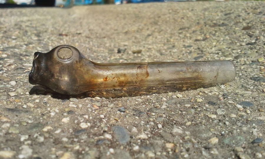 A dirty glass crack pipe lies in the gutter at the side of the road in this file photo. (iStock/Getty Images Plus)