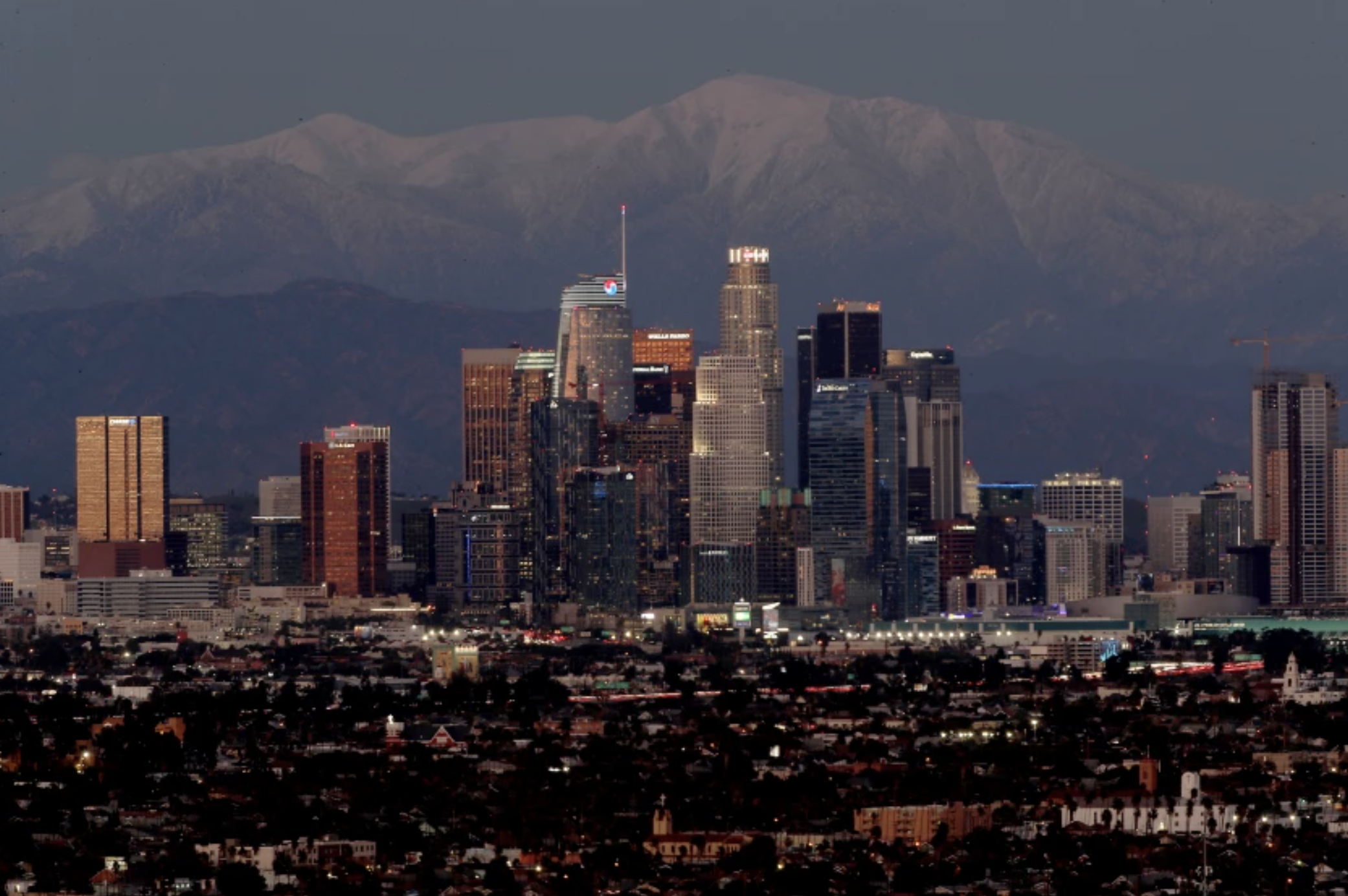 Snow covers Mt. Baldy behind the Los Angeles skyline on Wednesday. The recent cold weather is expected to give way to a warming trend. (Luis Sinco/Los Angeles Times)