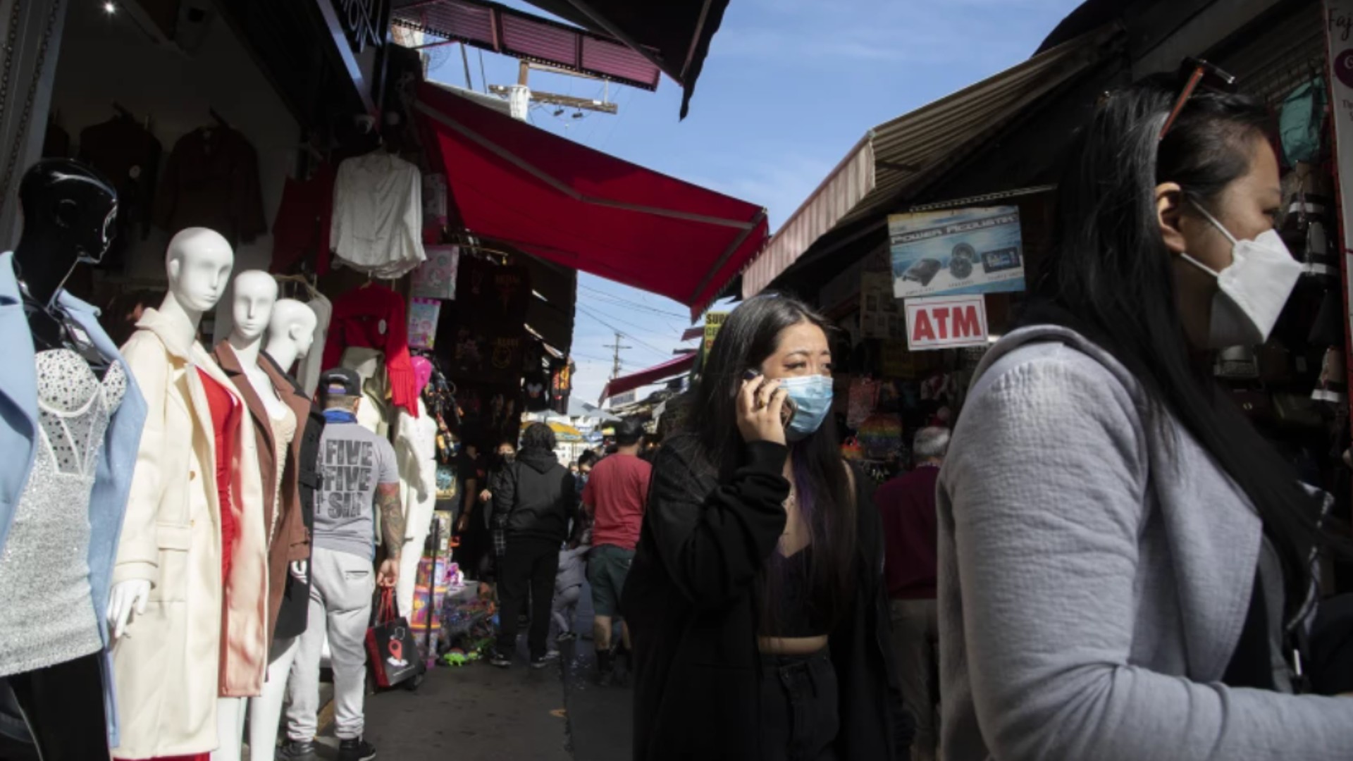 Masked shoppers navigate Santee Alley in downtown Los Angeles. The state is set to ease mask restrictions next week, but L.A. County will continue to take a more cautious approach.(Myung J. Chun / Los Angeles Times)