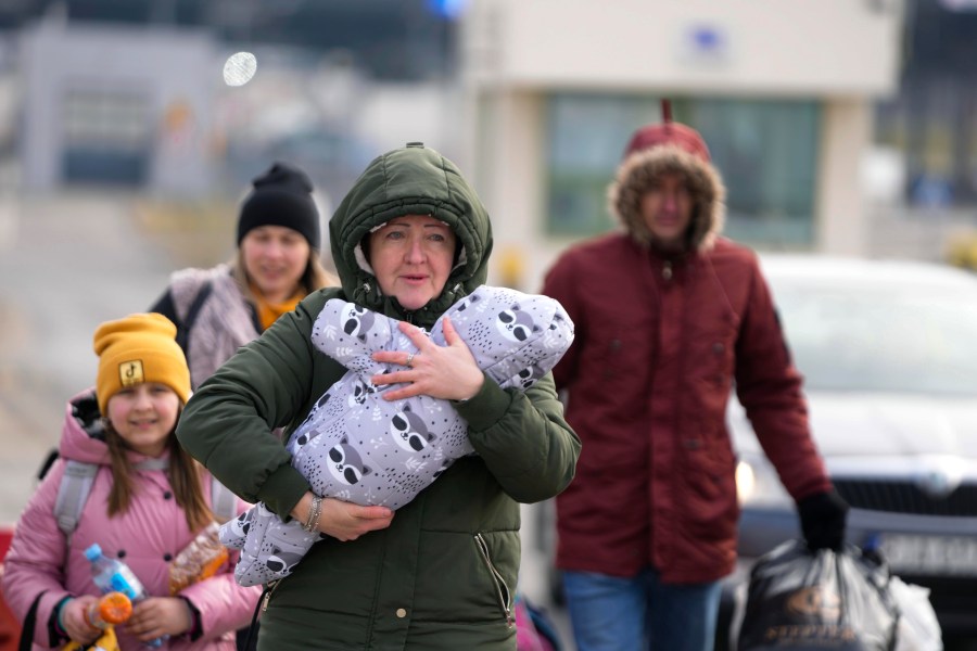 A family arrive at the border crossing in Medyka, Poland, Wednesday, March 2, 2022, after fleeing from the Ukraine. The U.N. refugee agency said Tuesday that around 660,000 people have fled Ukraine for neighboring countries since the Russian invasion began. (AP Photo/Markus Schreiber)