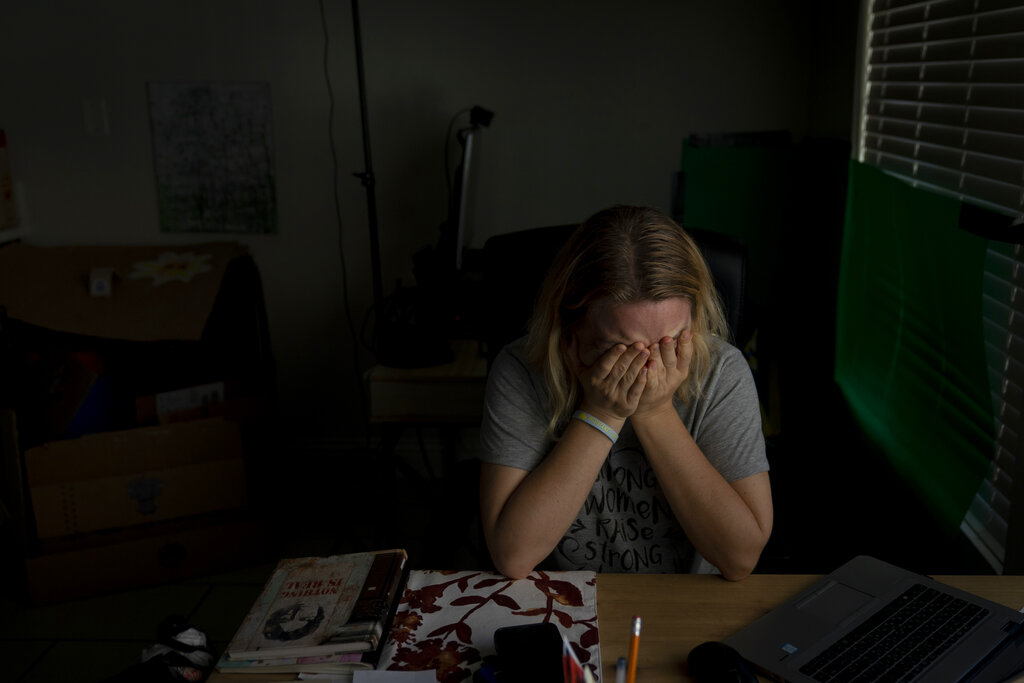 Hanna Tverdokhlib, a 37-year-old Ukrainian immigrant, breaks down in tears after talking on the phone with her friend in Ukraine Tuesday, March 1, 2022, in Long Beach, Calif. Tverdokhlib has held her phone as if it were glued to her hand since the Russian invasion of Ukraine last week. When she isn't watching news on it, she is texting her cousins and close friends back home or checking their Facebook posts, hoping her cousins are still safe in the bunker underneath their Kiev apartment building where they run when the sirens go off. (AP Photo/Jae C. Hong)