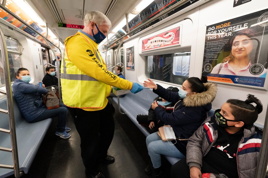 Patrick Foye, Chairman and CEO of the Metropolitan Transportation Authority, hands out face masks on a New York City subway, , Nov. 17, 2020, in New York. The Centers for Disease Control and Prevention is developing guidance that will ease the nationwide mask mandate for public transit next month. That's according to a U.S. official. (AP Photo/Mark Lennihan, File)