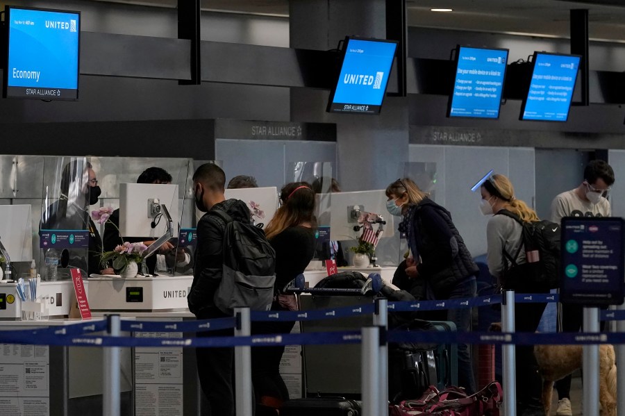 Travelers check in at United desks at San Francisco International Airport during the coronavirus outbreak in San Francisco, Tuesday, Nov. 24, 2020. The airline industry is raising the stakes in a fight over mandatory rest breaks under California law. A study commissioned by an airline trade group and released Tuesday, March 15, 2022, warns that unless the U.S. Supreme Court acts, travelers will face fewer flight options and higher fares.(AP Photo/Jeff Chiu)