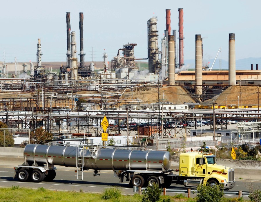 A tanker truck passes the Chevron oil refinery in Richmond, Calif., on March 9, 2010. More than 500 workers at the Chevron Corp. refinery in the San Francisco Bay area have told the company they will go on strike at 12:01 a.m. Monday, March 21, 2022. The United Steelworkers union says Sunday, March 20 that members of Local 5 voted down Chevron's most recent contract offer and gave notice of intent to go on strike. (AP Photo/Paul Sakuma, File)