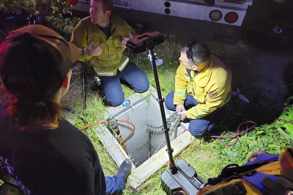 In this image provided by the Contra Costa County Fire Protection District, emergency personnel work on rescuing a man from an underground storm water pipe in Antioch, Calif., Sunday, March 20, 2022. (Steve Hill/Contra Costa County Fire Protection District via AP)