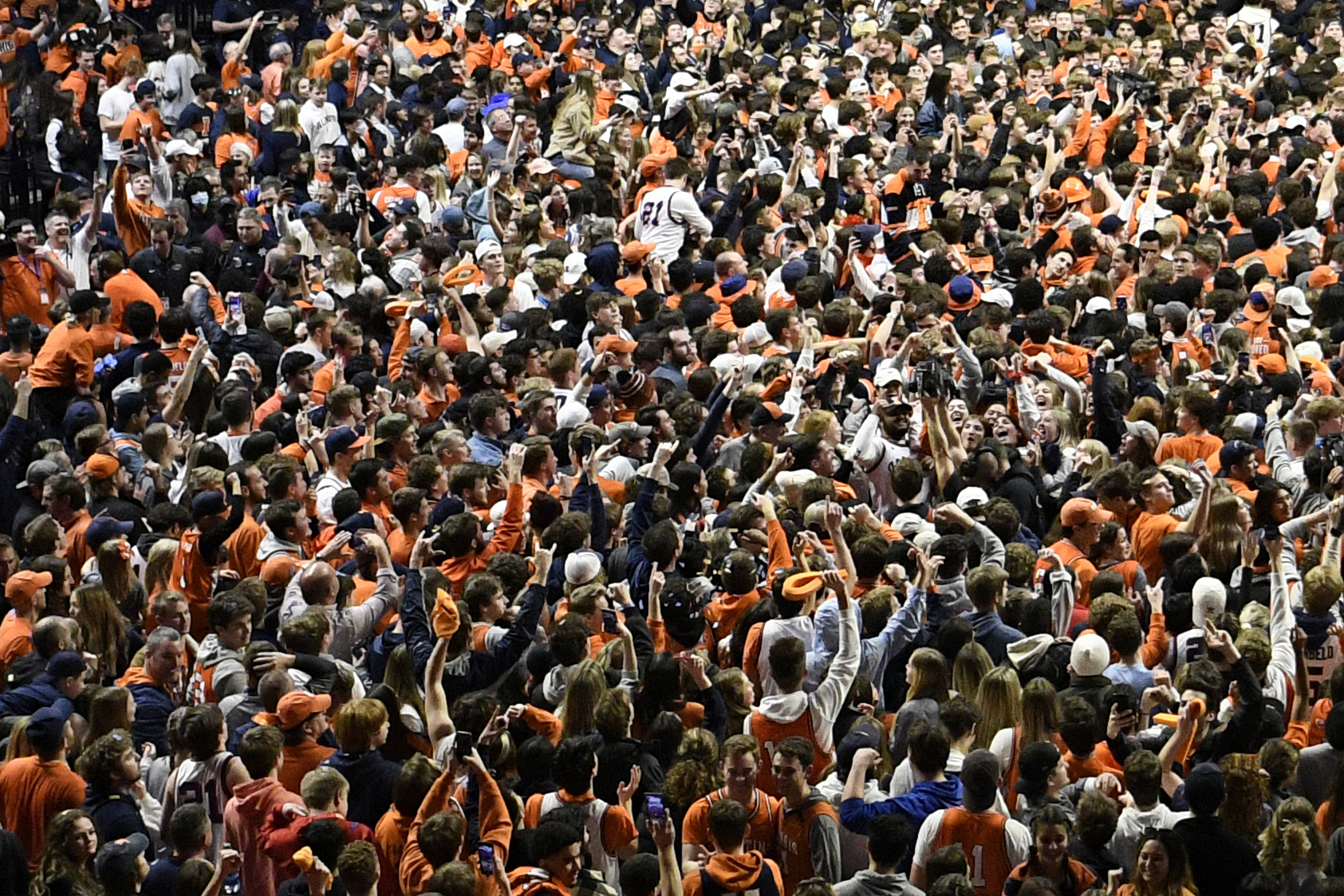 Fans storm the court at the conclusion of a college basketball game in Champaign, Ill., on March 6, 2022. (Michael Allio/Associated Press)