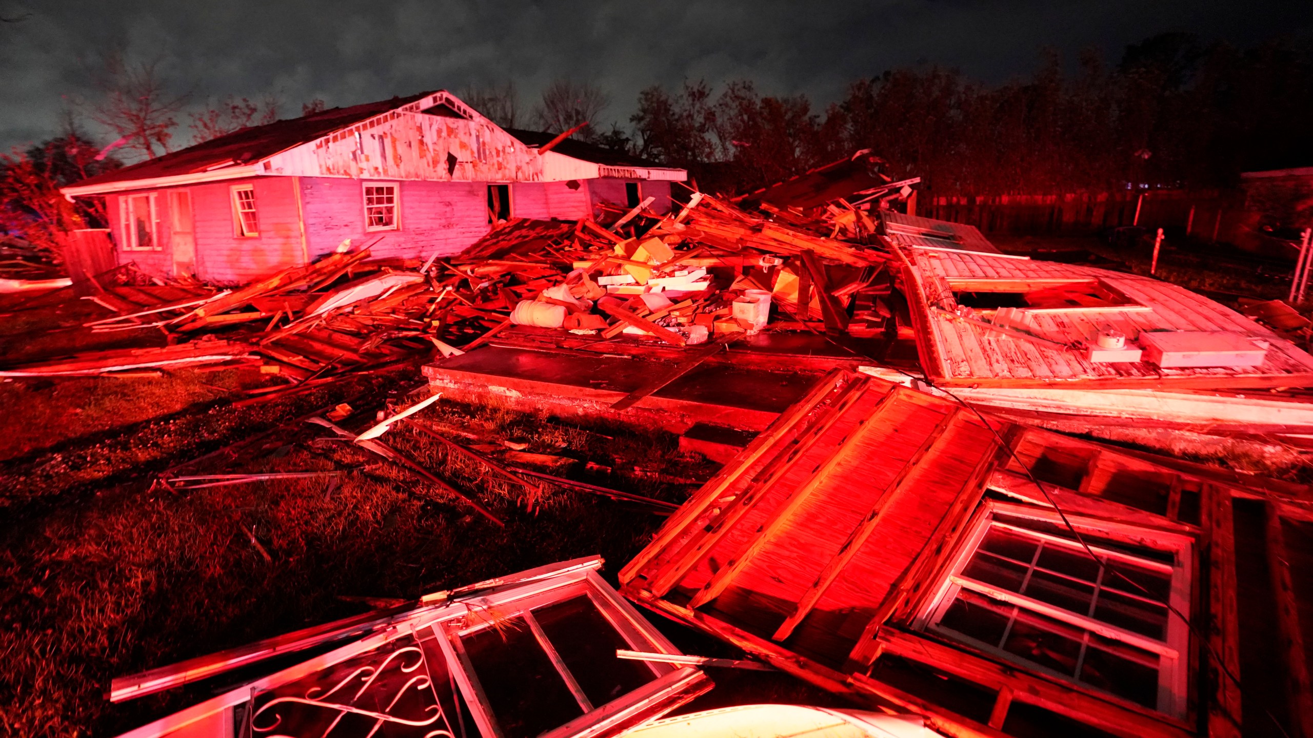 Destroyed homes, illuminated by fire engine lights, are seen after a tornado struck the area in Arabi, La., Tuesday, March 22, 2022. A tornado tore through parts of New Orleans and its suburbs Tuesday night, ripping down power lines and scattering debris in a part of the city that had been heavily damaged by Hurricane Katrina 17 years ago. (AP Photo/Gerald Herbert)