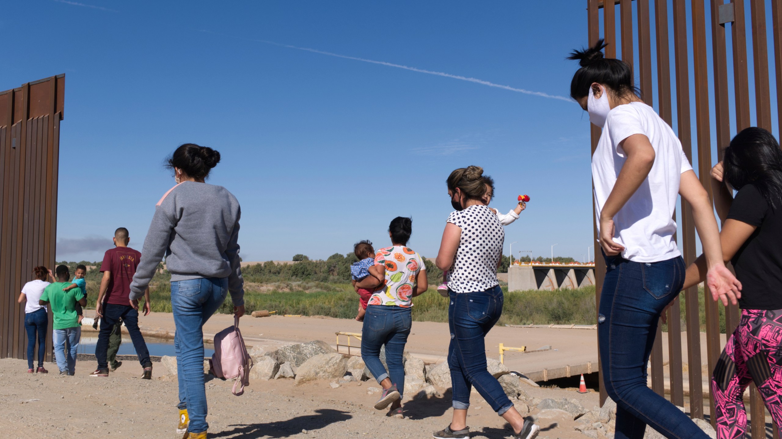 A group of Brazilian migrants make their way around a gap in the U.S.-Mexico border in Yuma, Ariz., seeking asylum in the United States after crossing over from Mexico, June 8, 2021. border. The Biden administration has unveiled new procedures to handle asylum claims at the U.S. southern border, hoping to decide cases in months instead of years. The rules empower asylum officers to grant or deny claims, an authority that has been limited to immigration judges for people arriving at the border with Mexico. (AP Photo/Eugene Garcia, File)