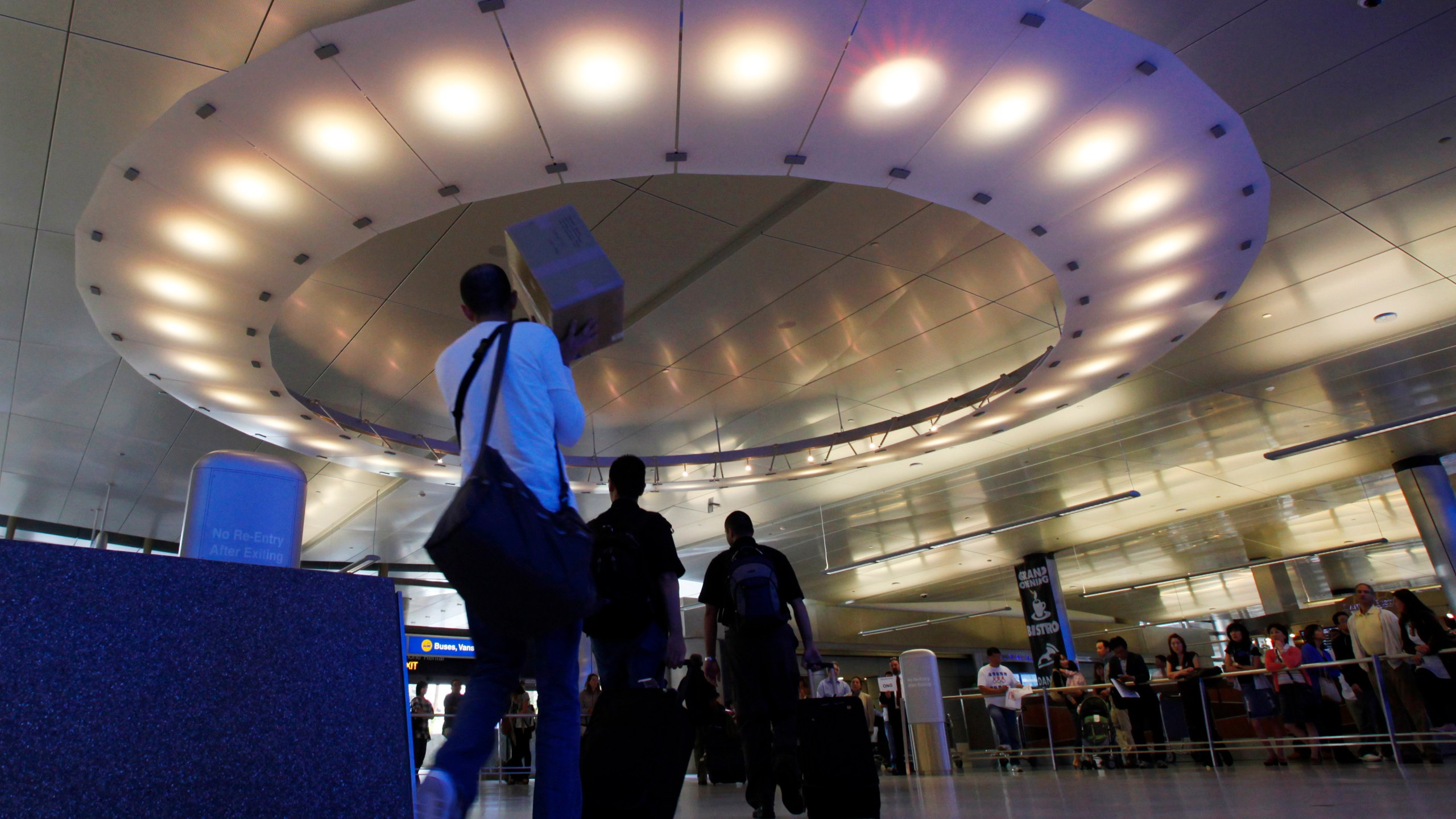 Arriving international passengers pass under a large "halo" of light in the area where they meet friends and family, at the customs clearance area at the Tom Bradley International Terminal at Los Angeles International Airport, May 28, 2010. Three Muslim Americans have filed a lawsuit alleging that U.S. border officers questioned them about their religious beliefs in violation of their constitutional rights when they returned from international travel. The three men from Minnesota, Texas and Arizona sued Department of Homeland Security officials on Thursday, March 24, 2022, in a federal court in Los Angeles. The suit was filed in California because some of the questioning allegedly occurred at Los Angeles International Airport. (AP Photo/Reed Saxon, File)