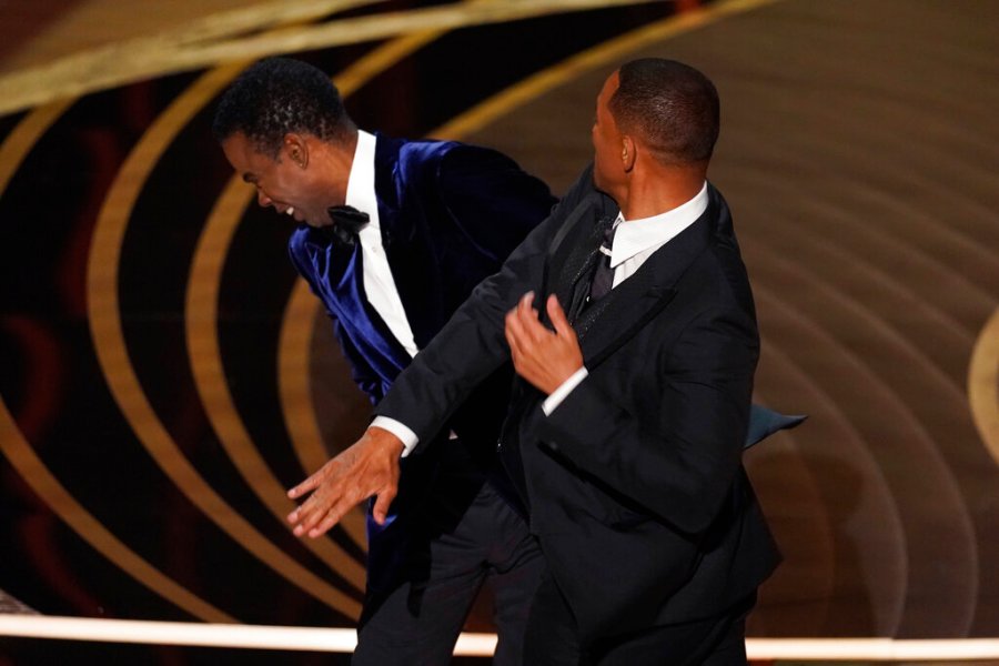 Will Smith, right, hits presenter Chris Rock on stage while presenting the award for best documentary feature at the Oscars on Sunday, March 27, 2022, at the Dolby Theatre in Los Angeles. (AP Photo/Chris Pizzello)