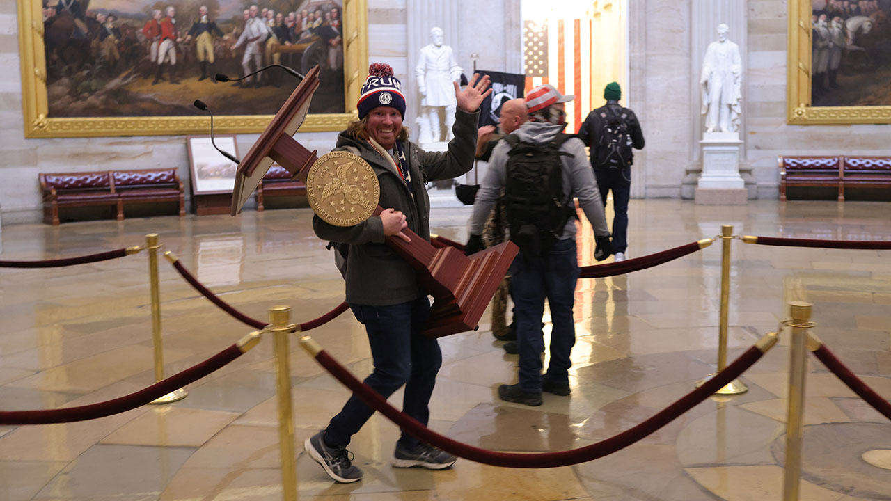 Adam Johnson carries the lectern of U.S. Speaker of the House Nancy Pelosi through the Rotunda of the U.S. Capitol Building. (Win McNamee/Getty Images)