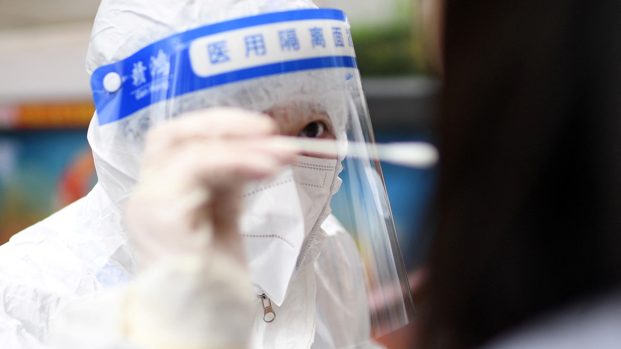 This file photo shows a medical worker getting a swab sample from a resident to test for the COVID-19 coronavirus in in China on Feb. 22, 2022. (STR/AFP via Getty Images)