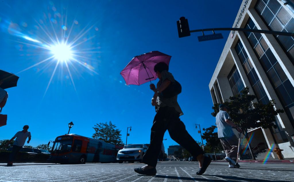 A pedestrian uses an umbrella on a hot sunny morning in Los Angeles October 24, 2017.