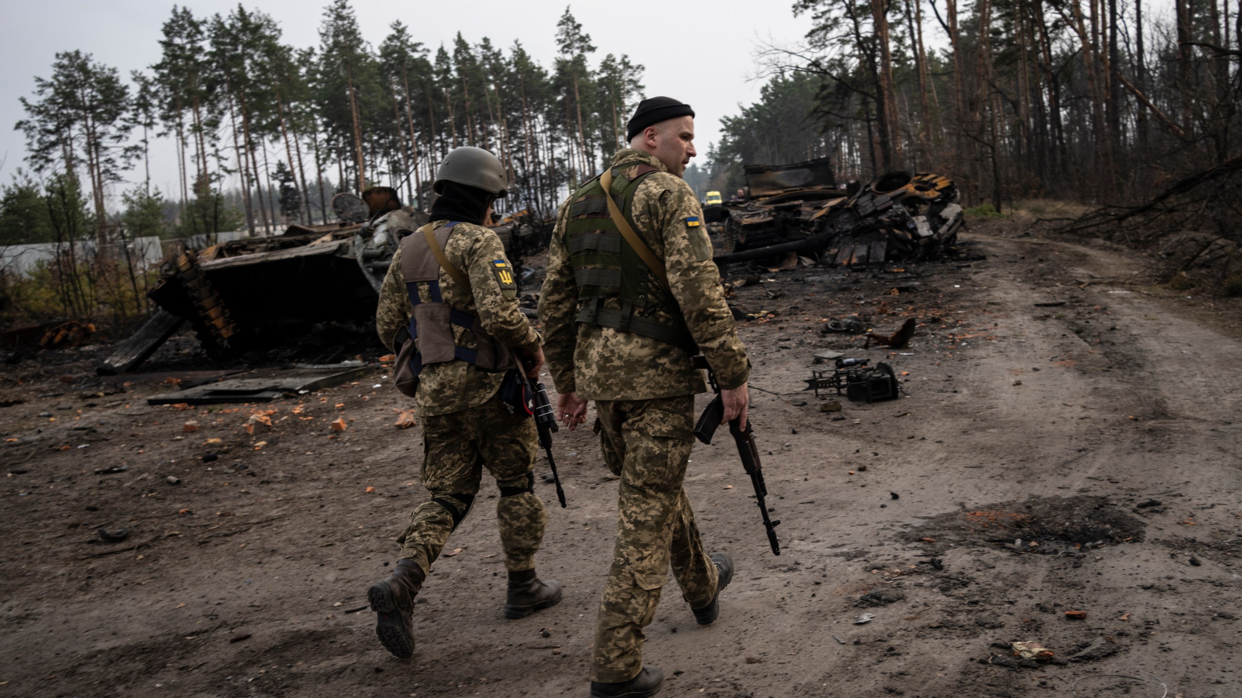 Ukrainian soldiers walk next to destroyed Russian tanks in the outskirts of Kyiv, Ukraine, Thursday, March 31, 2022. Russian forces shelled Kyiv suburbs, two days after the Kremlin announced it would significantly scale back operations near both the capital and the northern city of Chernihiv to “increase mutual trust and create conditions for further negotiations.” (AP Photo/Rodrigo Abd)