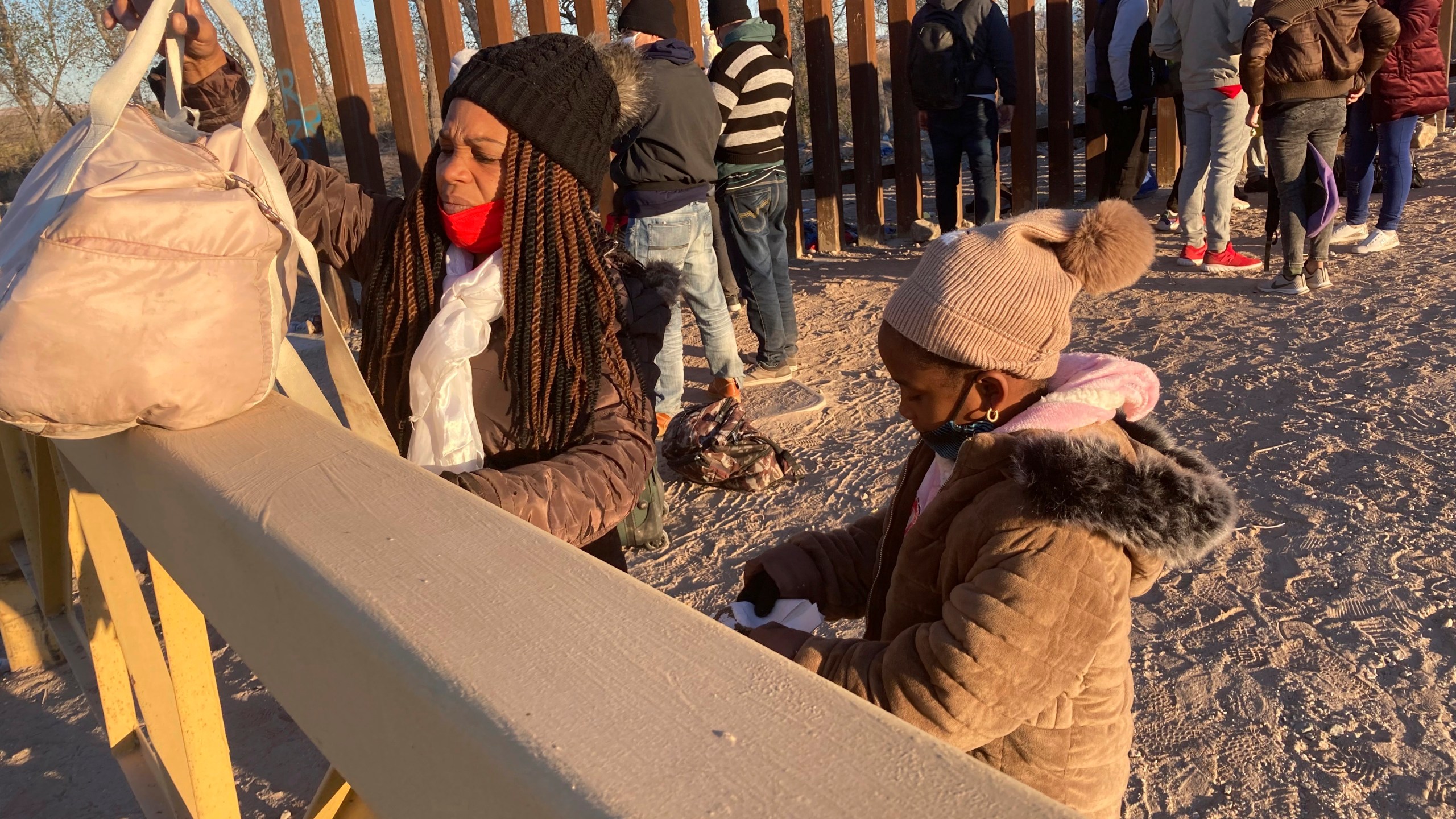 A Cuban woman and her daughter wait in line to be escorted to a Border Patrol van for processing in Yuma, Ariz., Feb. 6, 2022, hoping to remain in the United States to seek asylum. “This is a crisis, and in my estimation, because of a lack of planning from the administration, it’s about to get worse,” said Sen. Mark Kelly of Arizona. Kelly and fellow Arizona Democratic Sen. Kyrsten Sinema met Wednesday, March 30, with Homeland Security Secretary Alejandro Mayorkas to press their case for the administration to better plan and coordinate a response. (AP Photo/Elliot Spagat, File)