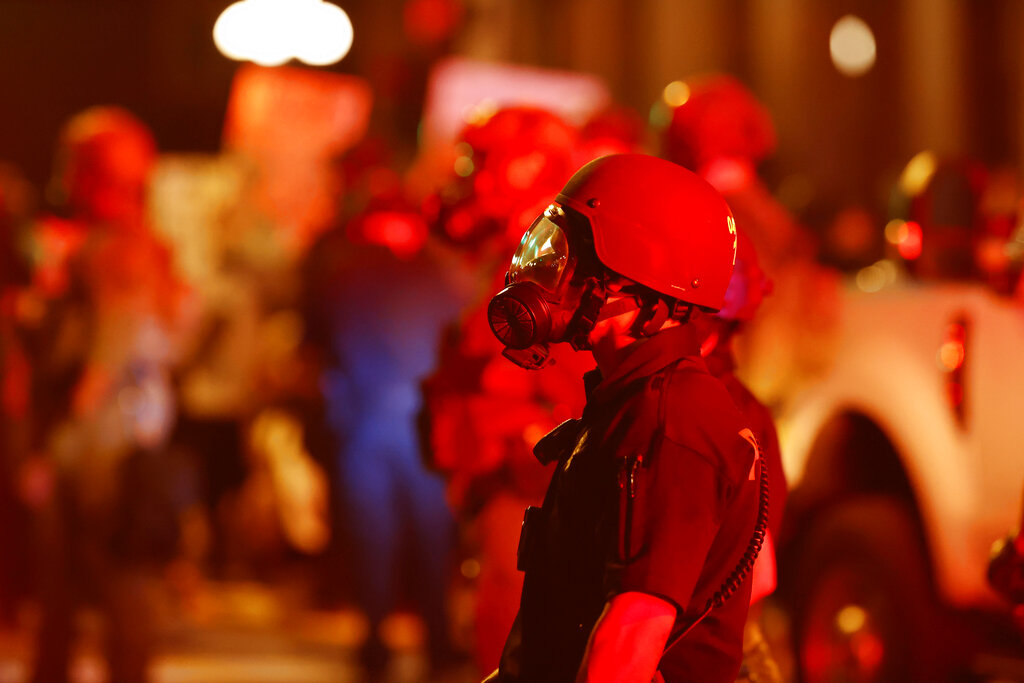 A Denver Police officer wears a gas mask before tear gas and rubber bullets were used to disperse protesters outside the State Capitol over the death of George Floyd, Thursday, May 28, 2020, in Denver. (AP Photo/David Zalubowski, File)