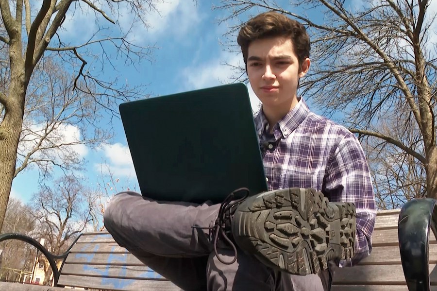 Harvard freshman Marco Burstein, 18, of Los Angeles, works on his computer near the campus of Harvard University in Cambridge, Mass., March 16, 2022. (AP Photo/Rodrique Ngowi)