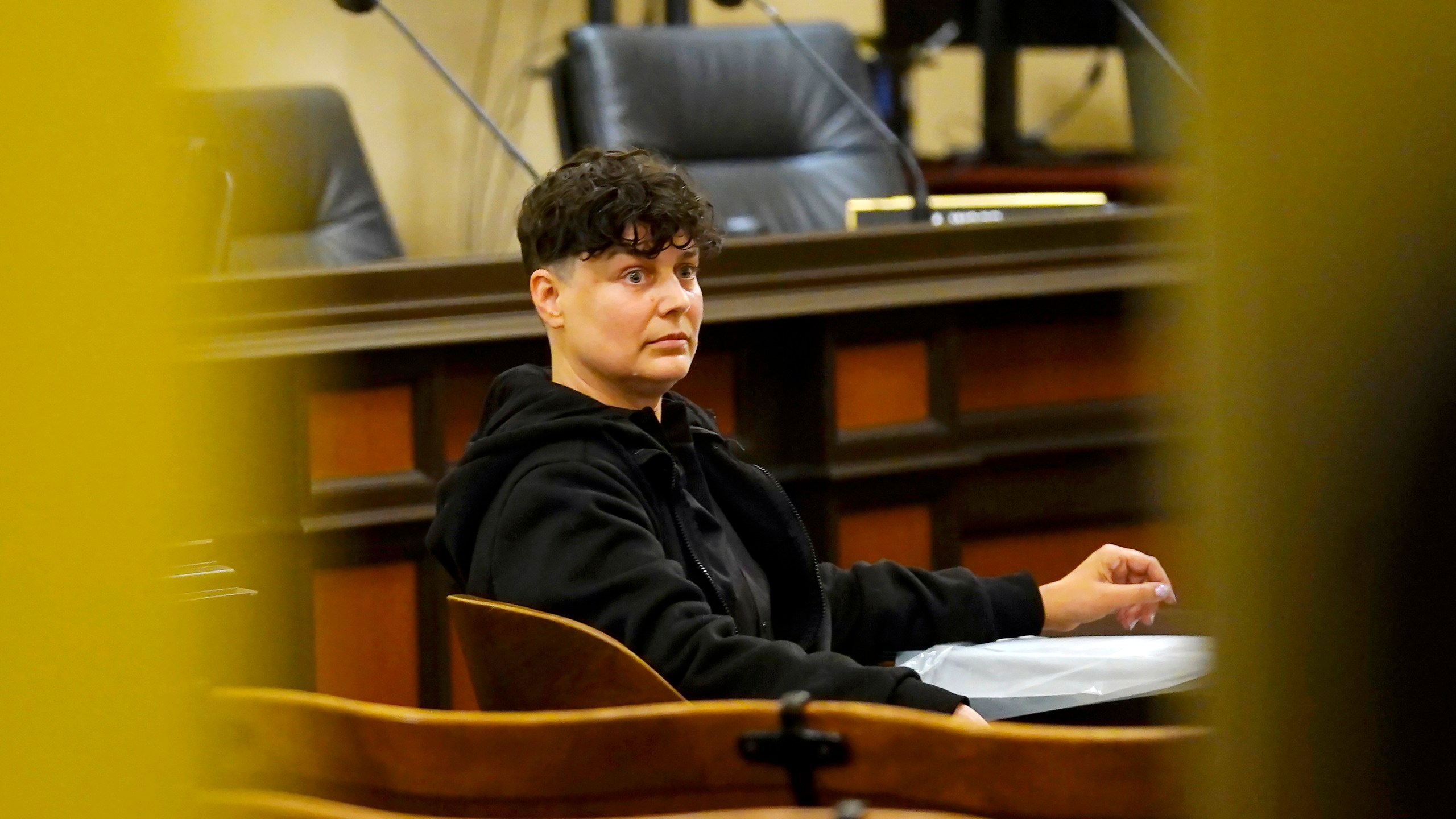 Carla Cabral sits at a table after disrupting a hearing of the Assembly Agriculture Committee in Sacramento, Calif., on April 6, 2022. Cabral, an animal rights organizer, glued her hand to a table and refused to leave. (AP Photo/Rich Pedroncelli)