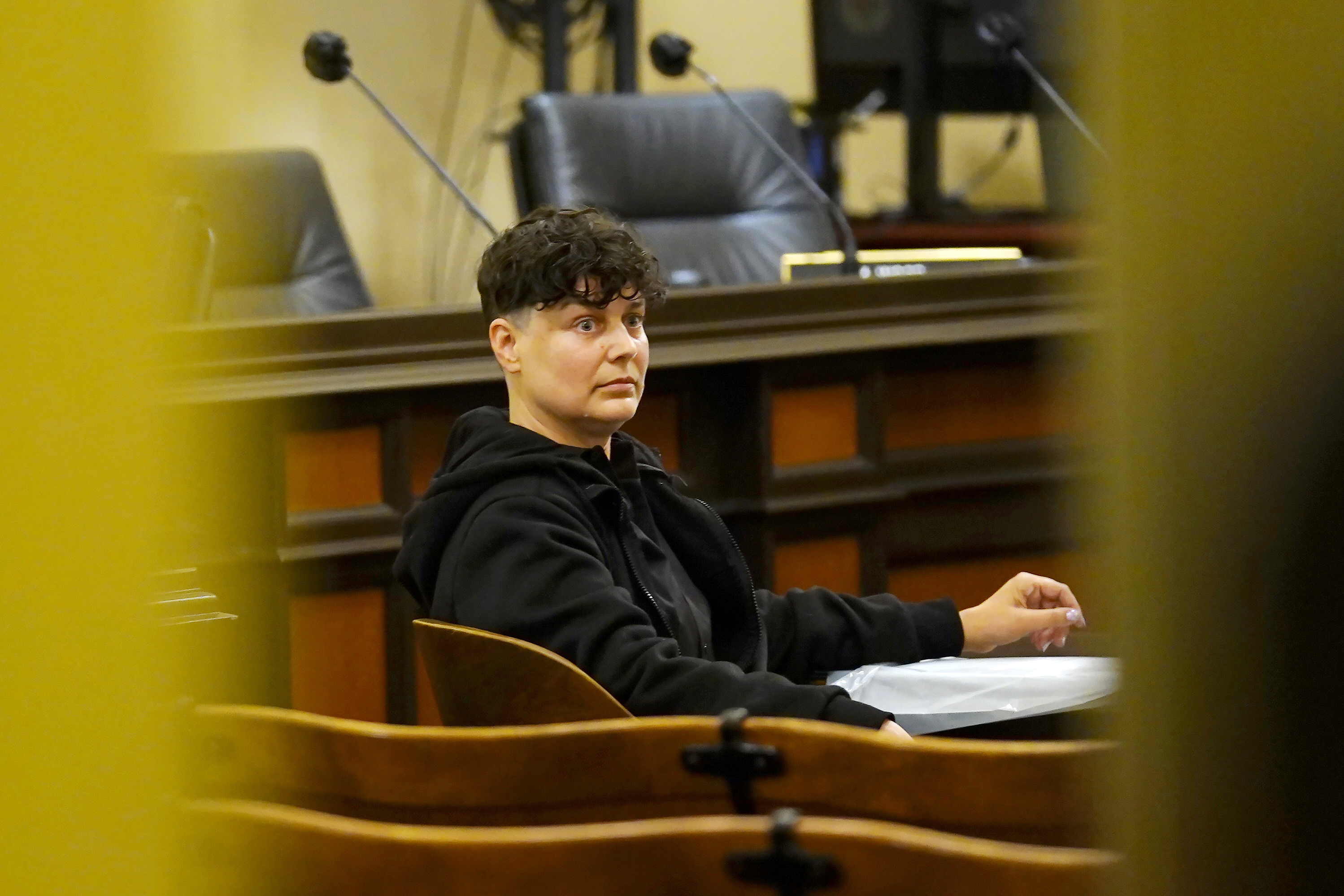 Carla Cabral sits at a table after disrupting a hearing of the Assembly Agriculture Committee in Sacramento, Calif., on April 6, 2022. Cabral, an animal rights organizer, glued her hand to a table and refused to leave. (AP Photo/Rich Pedroncelli)