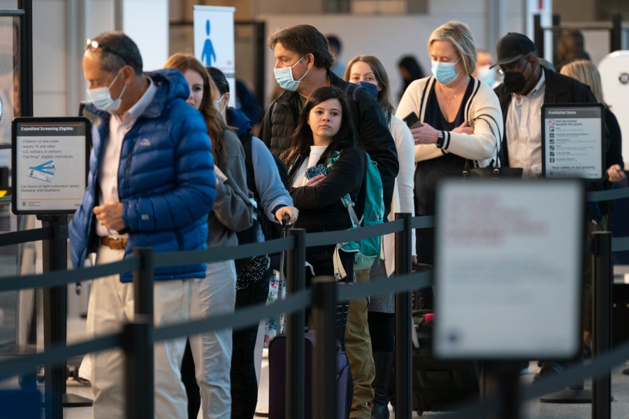 Passengers wait in line at the security checkpoint at Ronald Reagan Washington National Airport on April 19, 2022. (Evan Vucci/Associated Press)