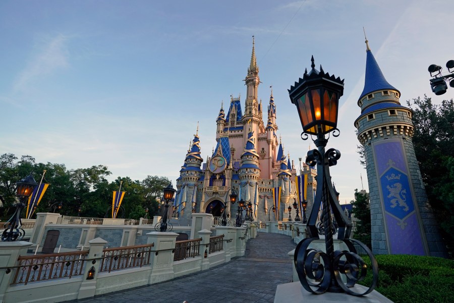 The newly painted Cinderella Castle at the Magic Kingdom at Walt Disney World is seen with the the crest to celebrate the 50th anniversary of the theme park Monday, Aug. 30, 2021, in Lake Buena Vista, Fla. (AP Photo/John Raoux, File)