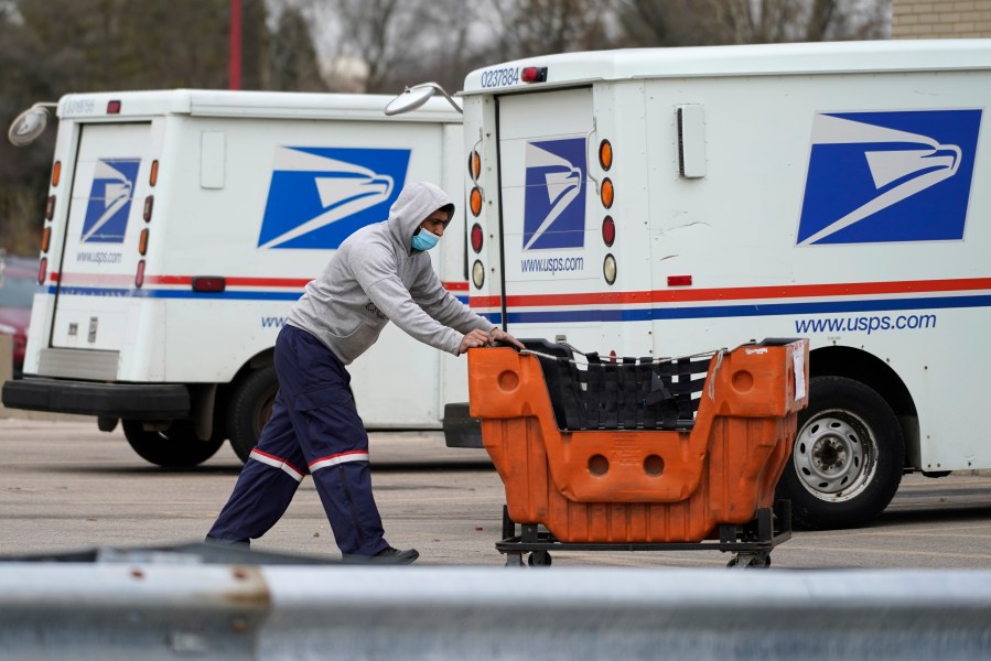 A United States Postal Service employee works outside a post office in Wheeling, Ill. on Dec. 3, 2021. (Nam Y. Huh/Associated Press)