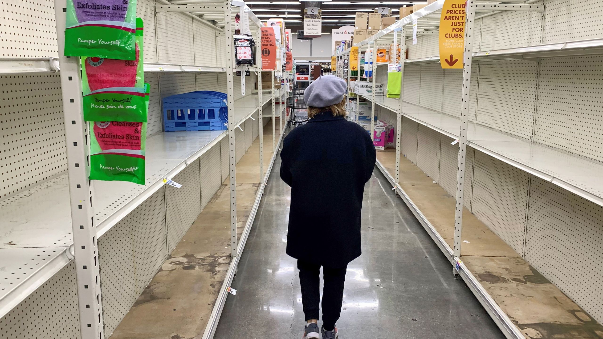 A shopper walks past empty shelves normally stocked with soaps, sanitizers, paper towels, and toilet paper at a Smart & Final grocery store on March 7, 2020 in Glendale, California. (ROBYN BECK/AFP via Getty Images)