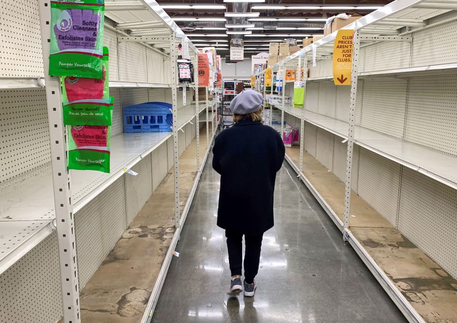 A shopper walks past empty shelves normally stocked with soaps, sanitizers, paper towels, and toilet paper at a Smart & Final grocery store on March 7, 2020 in Glendale, California. (ROBYN BECK/AFP via Getty Images)