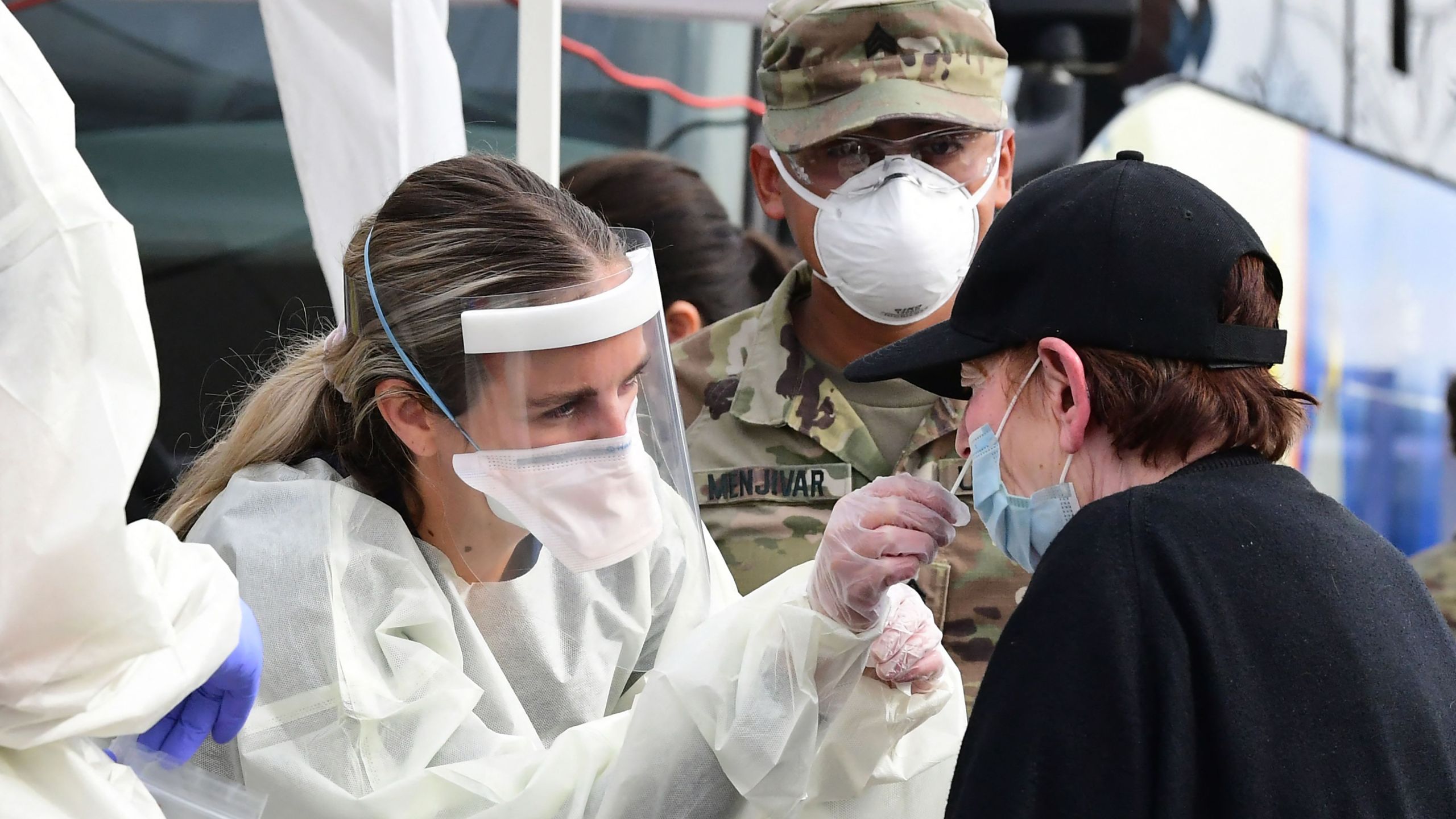 A woman receives help with a nasal swab at a Covid-19 mobile testing site in Paramount on January 12, 2022. (FREDERIC J. BROWN/AFP via Getty Images)