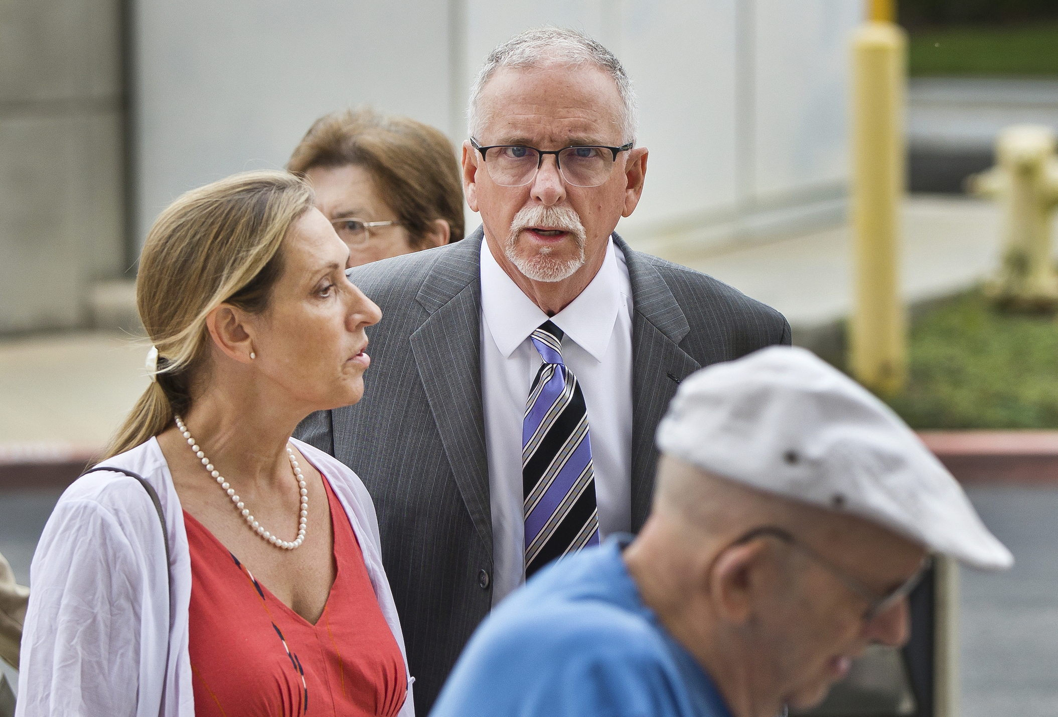 In this June 26, 2019 file photo, UCLA gynecologist James Heaps, center, and his wife, Deborah Heaps, arrive at Los Angeles Superior Court. (Damian Dovarganes/Associated Press)