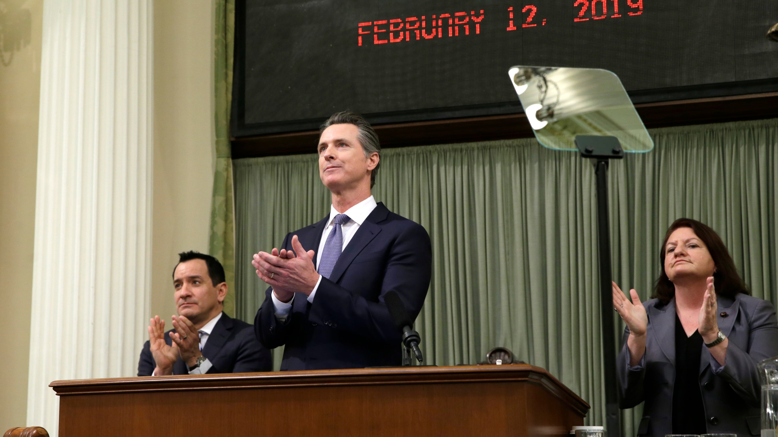 California Gov. Gavin Newsom, flanked by Assembly Speaker Anthony Rendon, left, and Senate President Pro Tempore Toni Atkins, right, applaud as introductions are made during Newsom's first State of the State address at the Capitol, on, Feb. 12, 2019. (Rich Pedroncelli/Associated Press)