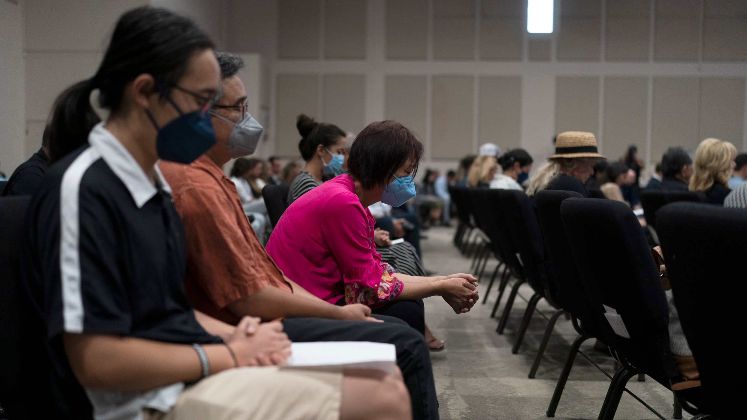 People pray during a prayer vigil in Irvine, Calif., Monday, May 16, 2022. The vigil was held to honor victims in Sunday's shooting at Geneva Presbyterian Church in Laguna Woods, Calif. Authorities say a Chinese-born gunman was motivated by hatred against Taiwan when he chained shut the doors of the California church and hid firebombs before shooting at a gathering of mainly of elderly Taiwanese parishioners. (AP Photo/Jae C. Hong)