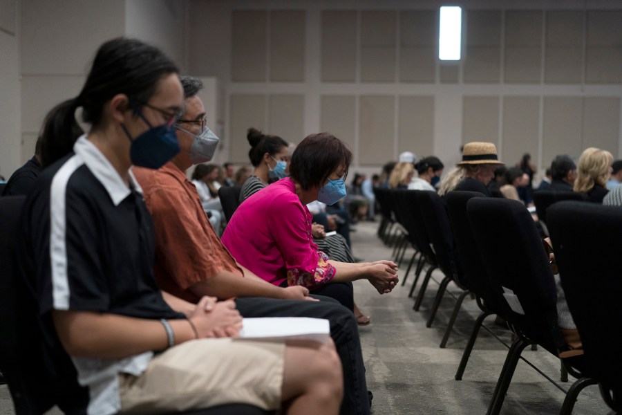 People pray during a prayer vigil in Irvine, Calif., Monday, May 16, 2022. The vigil was held to honor victims in Sunday's shooting at Geneva Presbyterian Church in Laguna Woods, Calif. Authorities say a Chinese-born gunman was motivated by hatred against Taiwan when he chained shut the doors of the California church and hid firebombs before shooting at a gathering of mainly of elderly Taiwanese parishioners. (AP Photo/Jae C. Hong)