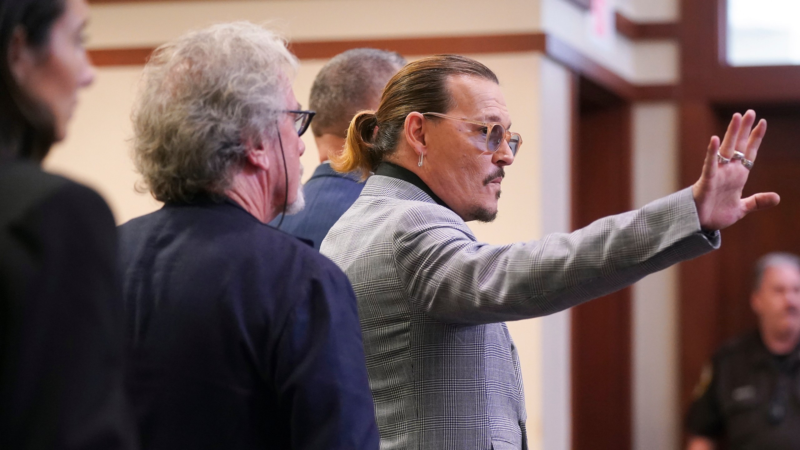 Actor Johnny Depp waves as he leaves the courtroom at the Fairfax County Circuit Courthouse in Fairfax, Va., Thursday, May 19, 2022. Actor Johnny Depp sued his ex-wife Amber Heard for libel in Fairfax County Circuit Court after she wrote an op-ed piece in The Washington Post in 2018 referring to herself as a "public figure representing domestic abuse." (Shawn Thew/Pool Photo via AP)