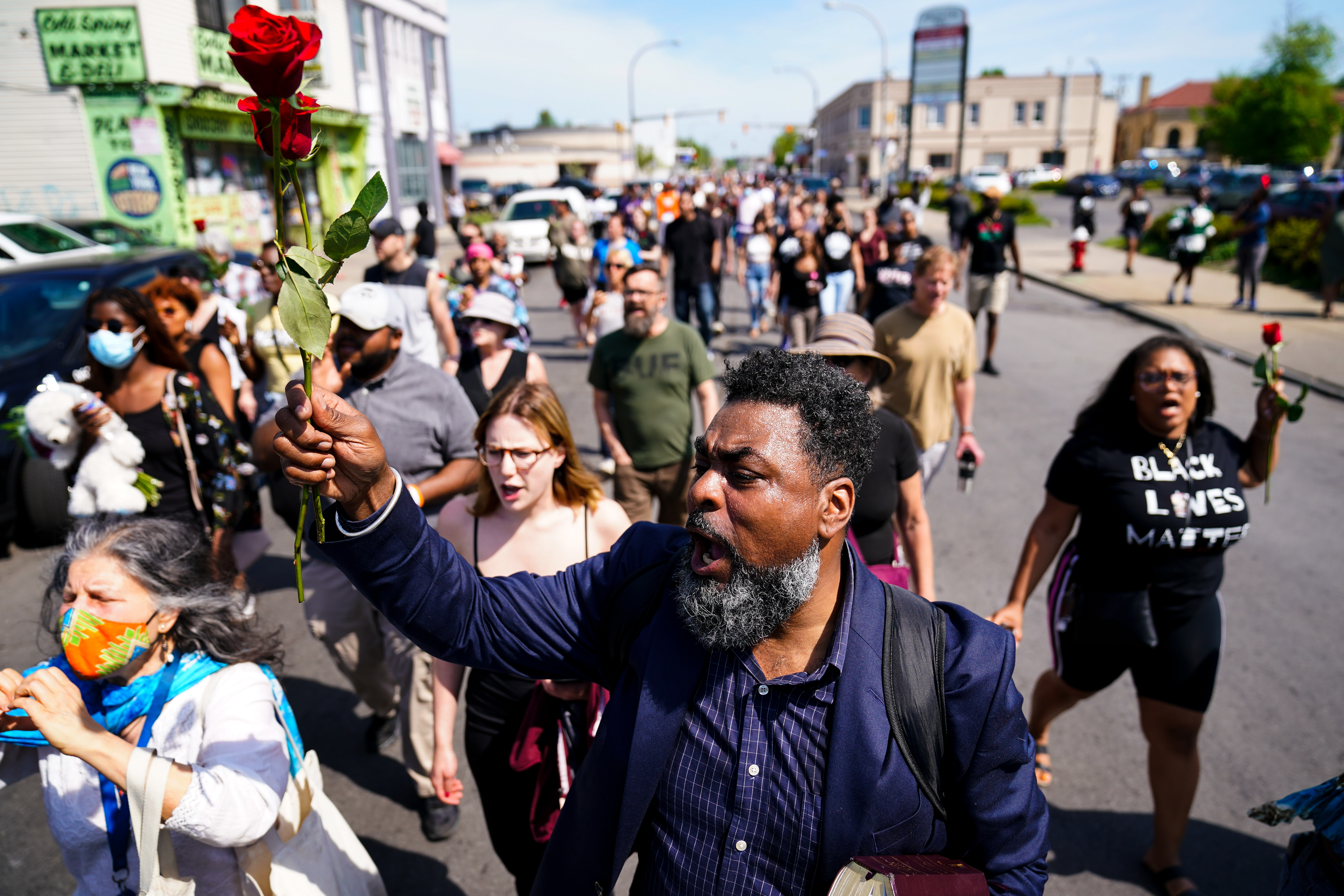 People march to the scene of a shooting at a supermarket in Buffalo, N.Y., Sunday, May 15, 2022. (AP Photo/Matt Rourke)