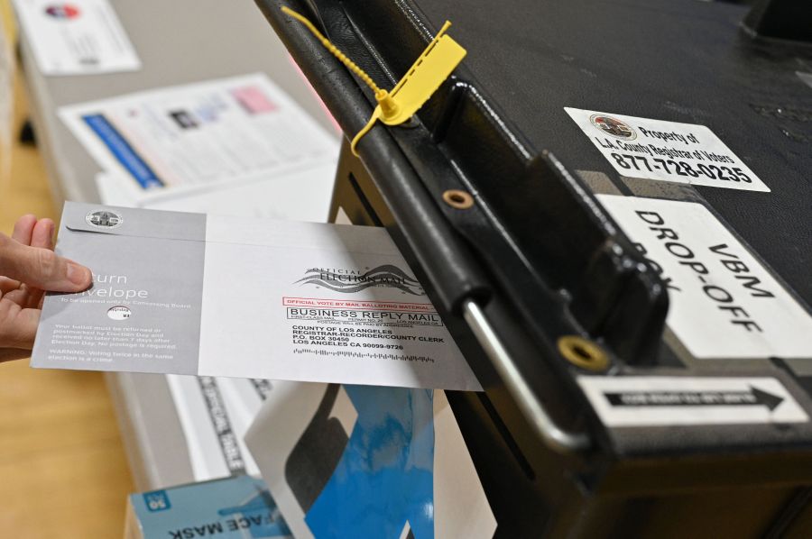 A voter drops her ballot into a ballot box in the California gubernatorial recall election at a polling station at Burbank High School in Burbank on Sept. 14, 2021. (ROBYN BECK/AFP via Getty Images)