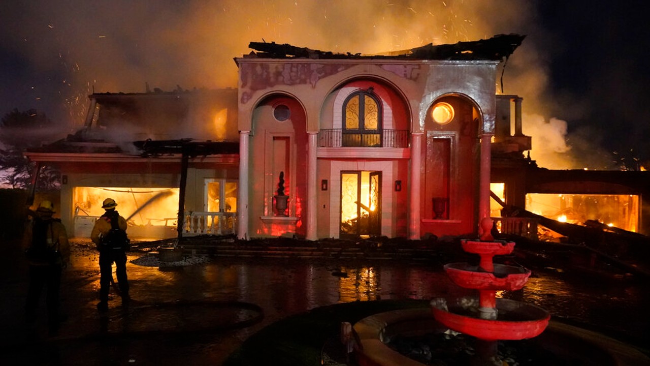 Firefighters work to put out a structure burning during a wildfire Wednesday, May 11, 2022, in Laguna Niguel, Calif. (AP Photo/Marcio J. Sanchez)