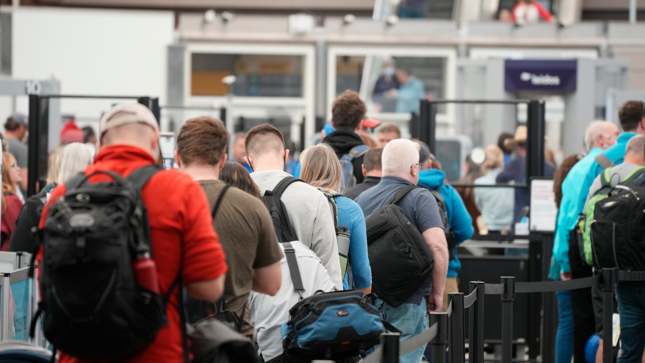 Travelers queue up at the north security checkpoint in the main terminal of Denver International Airport, Thursday, May 26, 2022, in Denver. Airlines canceled more than 1,000 flights by midmorning Friday, June 17, as they try to recover from storms that raked the center and eastern parts of the country. (AP Photo/David Zalubowski, File)