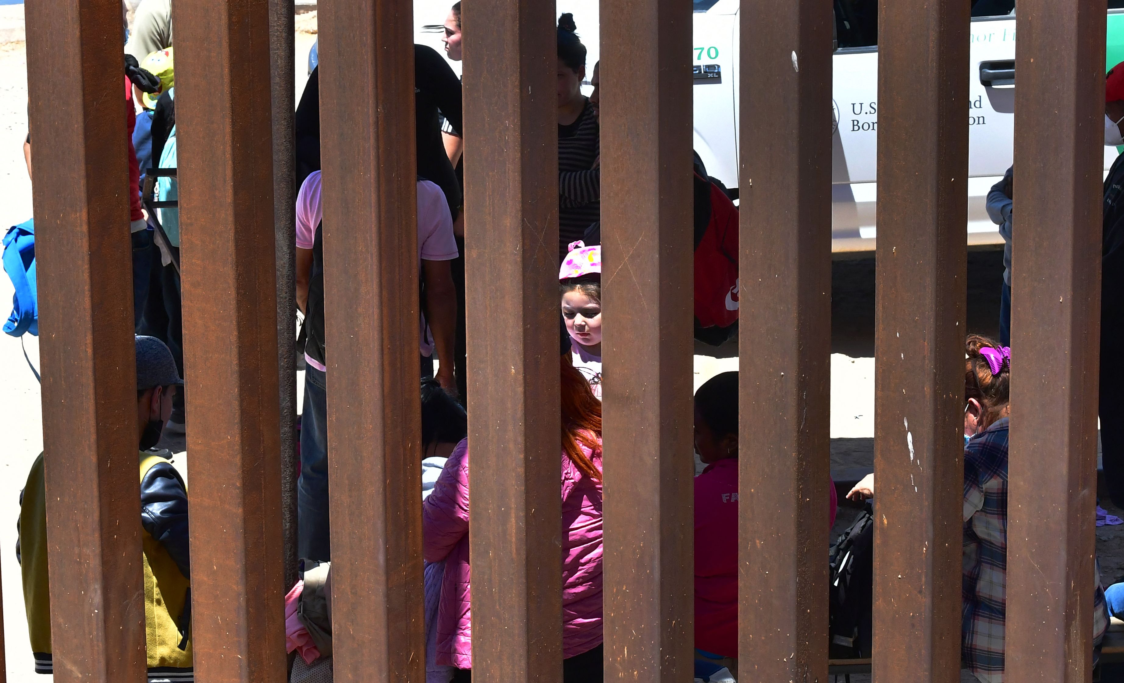 Migrants await processing by U.S. Border Patrol officers after attempting to cross from Algodones, Mexico to Yuma, Arizona on May 16, 2022. (FREDERIC J. BROWN/AFP via Getty Images)