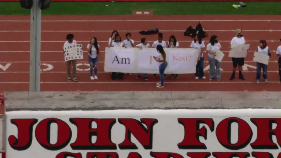 Students at Lakewood High School hold up a sign that read "Am I Next" during a rally on June 3, 2022. (KTLA)