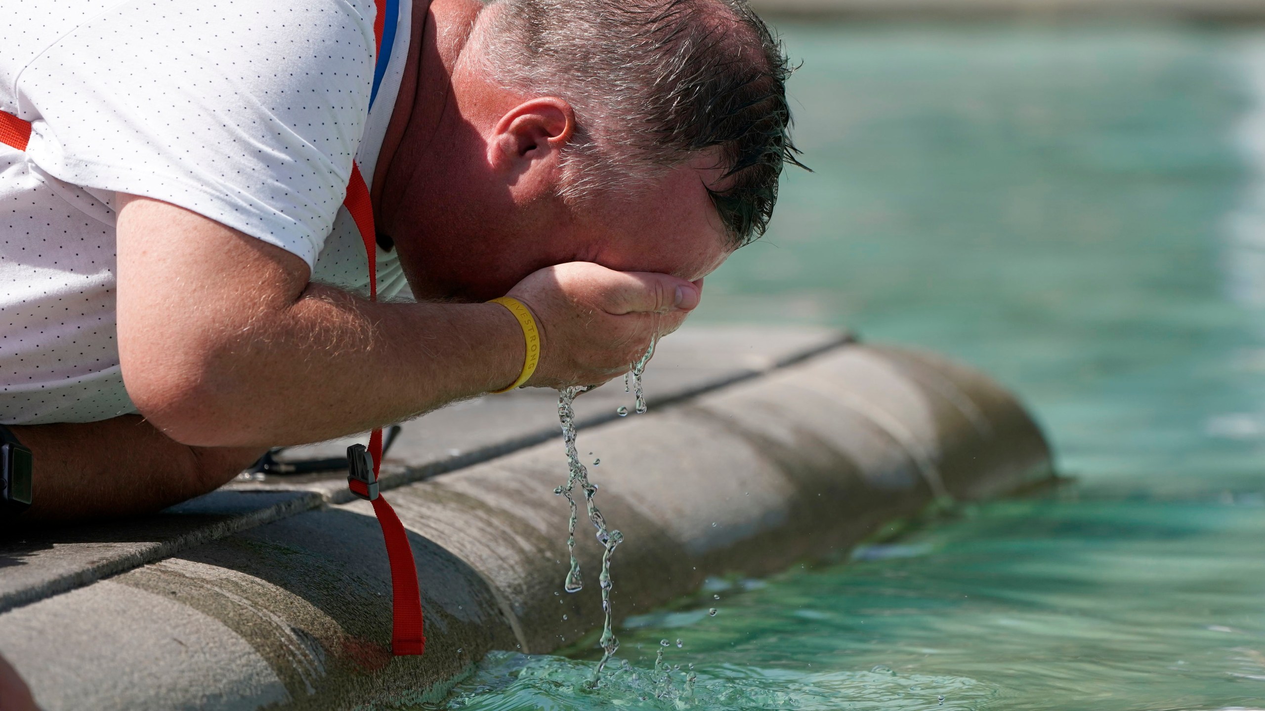 A man refreshes his face at a fountain in Trafalgar Square in central London on July 19, 2022. Britain shattered its record for highest temperature ever registered Tuesday, with a provisional reading of 39.1 degrees Celsius (102.4 degrees Fahrenheit), according to the country's weather office — and the heat was only expected to rise. (Aaron Chown/PA Wire/PA via AP)