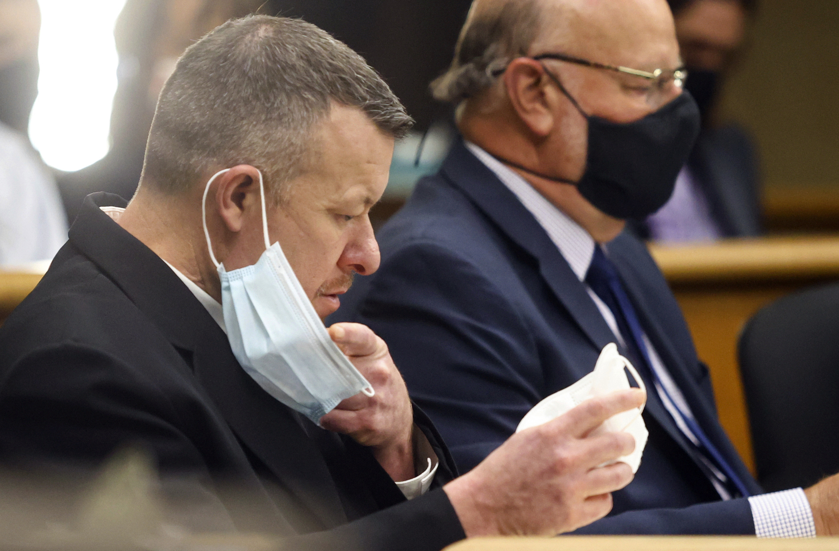 Paul Flores puts on a new N95 mask Aug. 3, 2021, at a preliminary hearing in San Luis Obispo, Calif. Kristin Smart disappeared during her freshman year at California Polytechnic State University in San Luis Obispo more than 25 years ago. She is presumed dead and her body remains missing but the man accused of killing her is going on trial Monday, July 18, 2022. Paul Flores is charged with murder and his father, Ruben Flores, is charged as an accomplice for allegedly helping him bury her body. The two have pleaded not guilty. (David Middlecamp/The Tribune of San Luis Obispo via AP, Pool, File)