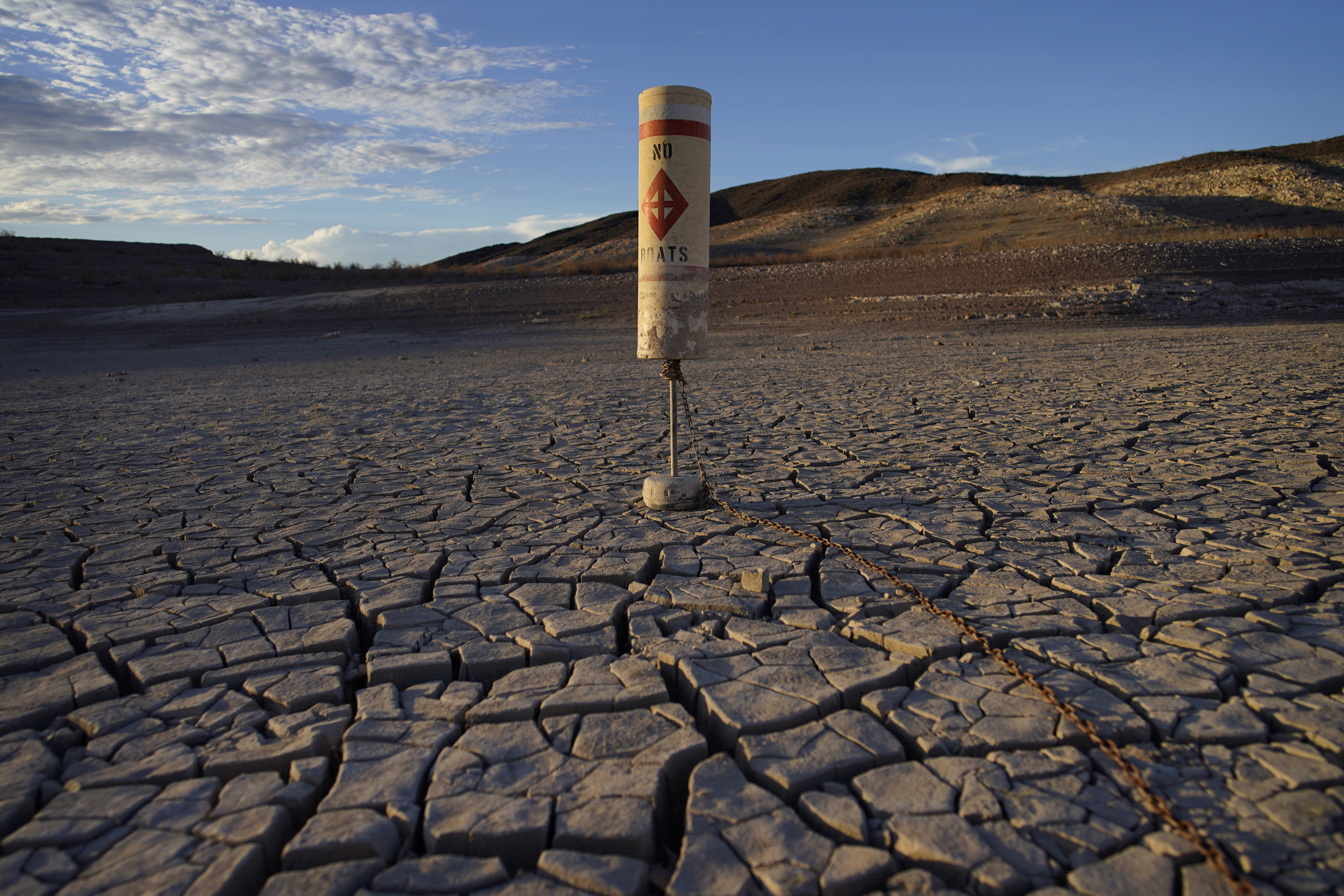 A buoy sits high and dry on cracked earth previously under the waters of Lake Mead at the Lake Mead National Recreation Area near Boulder City, Nev., on June 28, 2022. (John Locher/Associated Press)