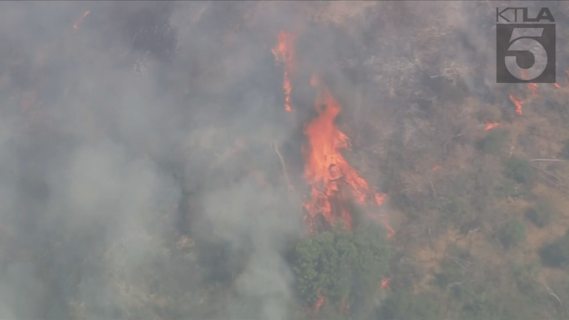 A brush fire burning in Azusa was reported to be threatening structures on Aug. 19, 2022. (KTLA)